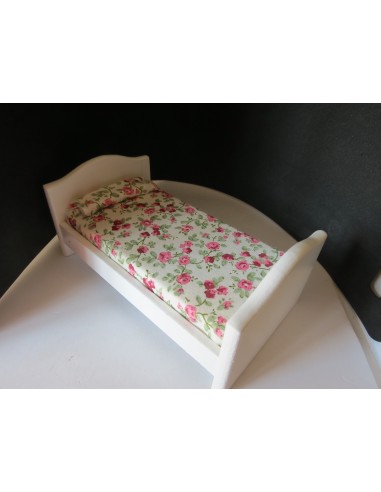 Cama en miniatura blanca de madera con colcha de flores